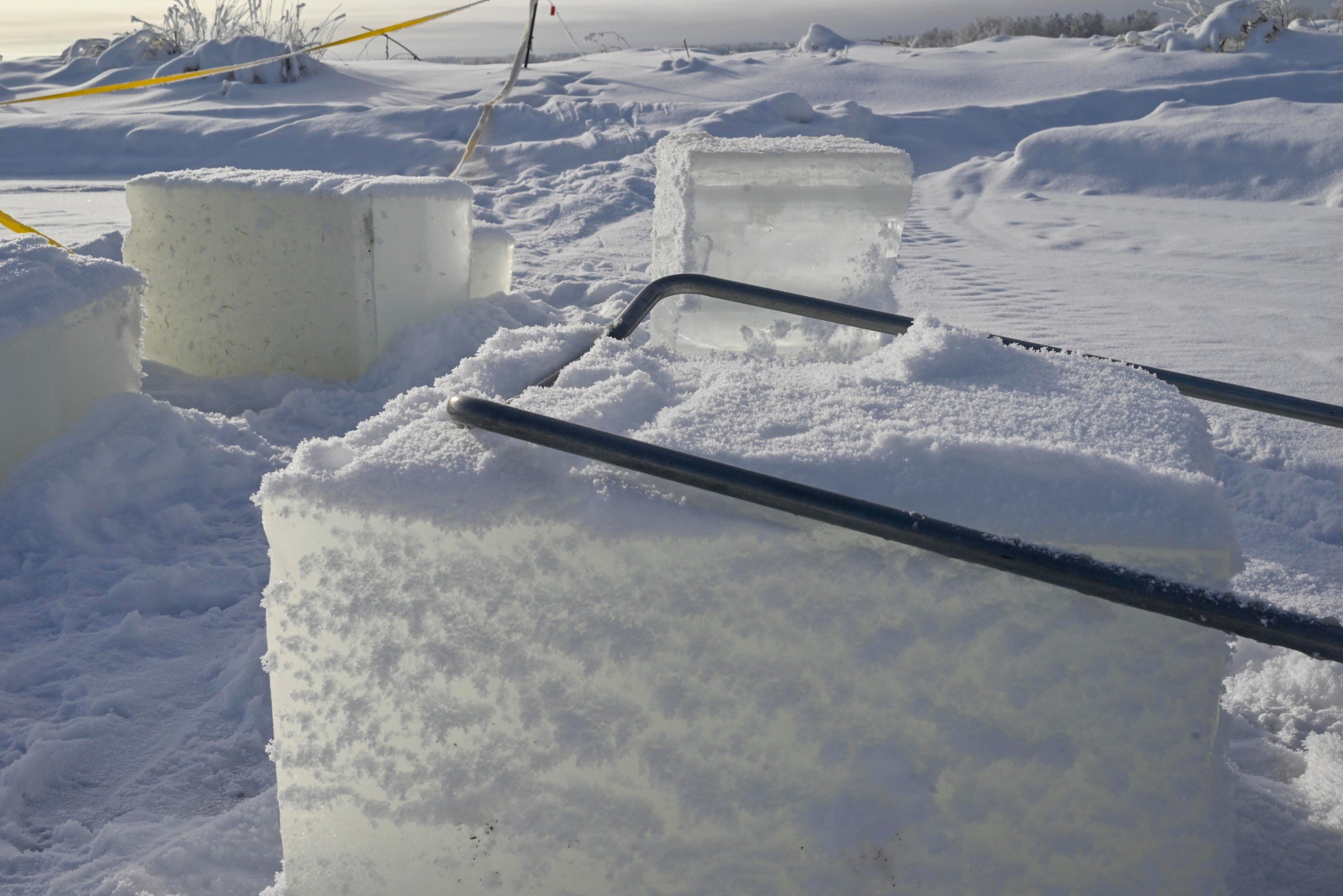 Luminen maisema. Rannalla on jäästä sahattuja kuutioita.